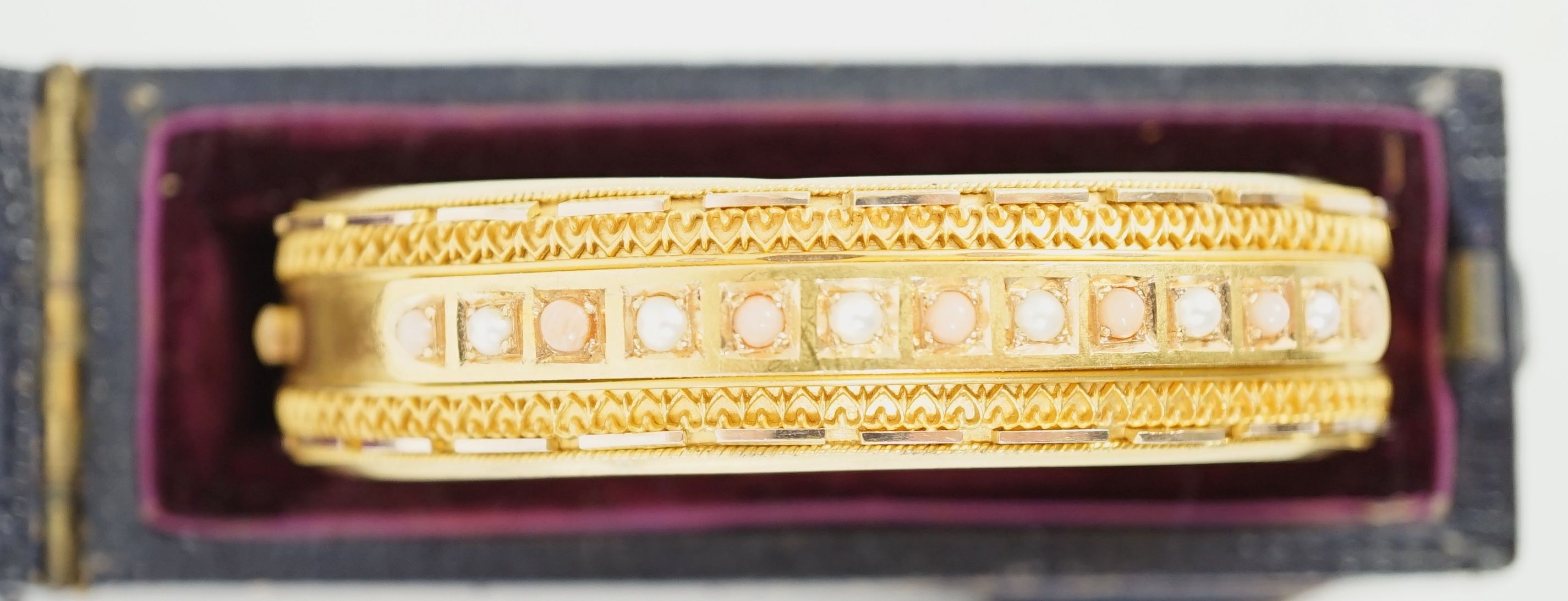 A late Victorian 15ct gold coral bead and seed pearl set part cannetile work hinged bangle